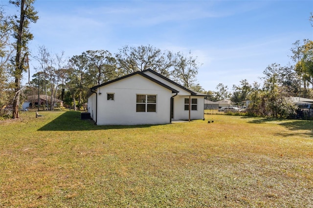 rear view of house featuring a lawn