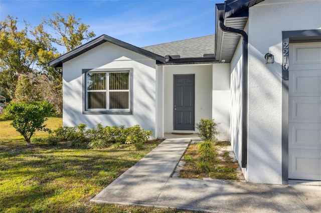 view of exterior entry with a yard