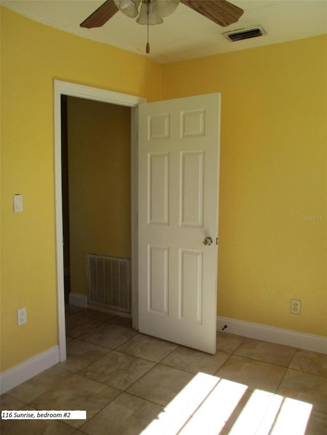 empty room featuring ceiling fan and light tile patterned flooring