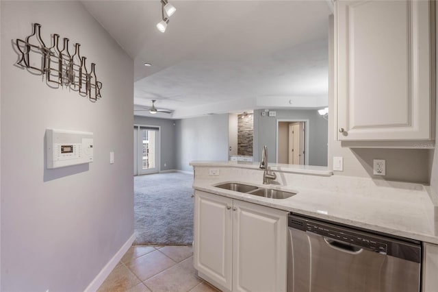 kitchen featuring dishwasher, sink, white cabinets, and light stone counters