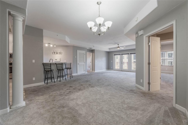 unfurnished living room with decorative columns, carpet, indoor wet bar, and french doors