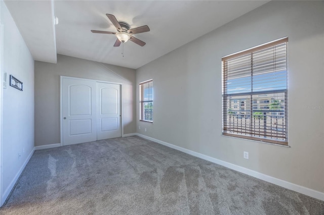 unfurnished bedroom featuring ceiling fan, a closet, and carpet