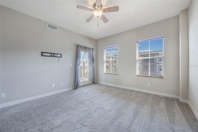 carpeted spare room featuring ceiling fan