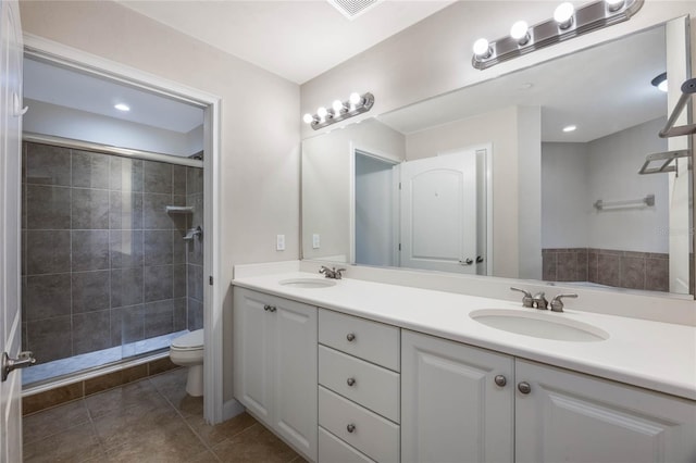 bathroom with tile patterned flooring, walk in shower, vanity, and toilet