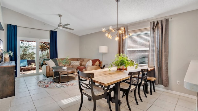 dining space featuring ceiling fan with notable chandelier, vaulted ceiling, a textured ceiling, and light tile patterned flooring