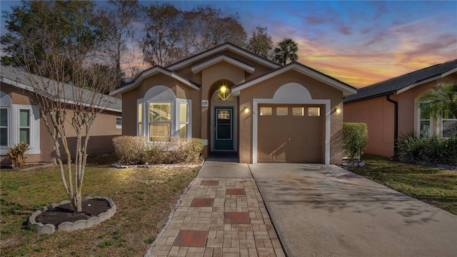 view of front of property with a garage and a yard