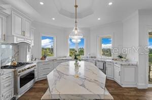 801 N Flagler Ave, Flagler Beach, FL 32136 - kitchen with hanging light fixtures, light stone countertops, white cabinets, and range with gas stovetop