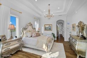 801 N Flagler Ave, Flagler Beach, FL 32136 - bedroom featuring a tray ceiling, ornamental molding, dark hardwood / wood-style floors, and a chandelier