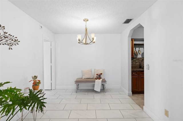 interior space with an inviting chandelier and a textured ceiling