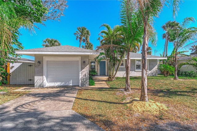 ranch-style home with a garage and a front lawn