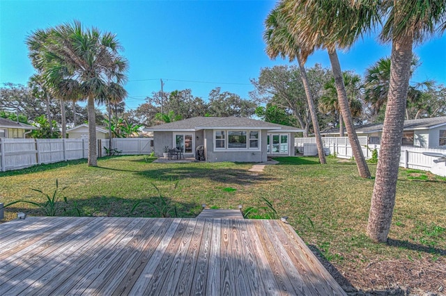 rear view of property with a wooden deck and a yard