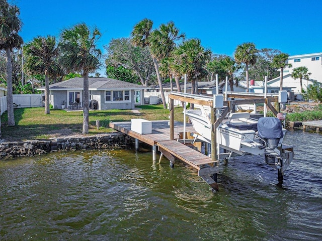 dock area with a water view and a lawn