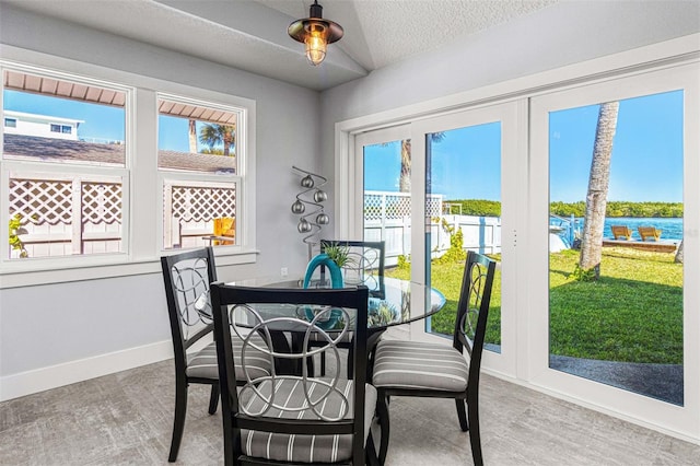 dining space with a textured ceiling and a water view