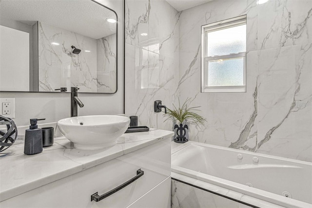 bathroom with tiled shower / bath, vanity, and a textured ceiling