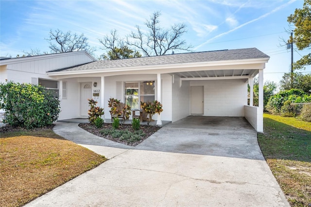 ranch-style house featuring a carport, covered porch, and a front yard