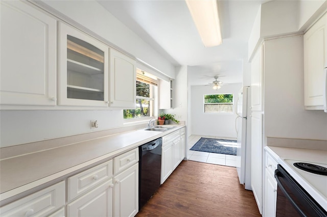 kitchen with white cabinetry, black dishwasher, sink, and white fridge