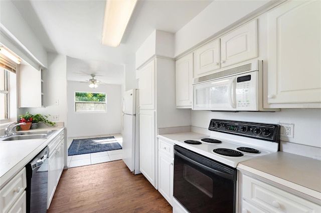 kitchen with dark hardwood / wood-style flooring, sink, white appliances, and white cabinets