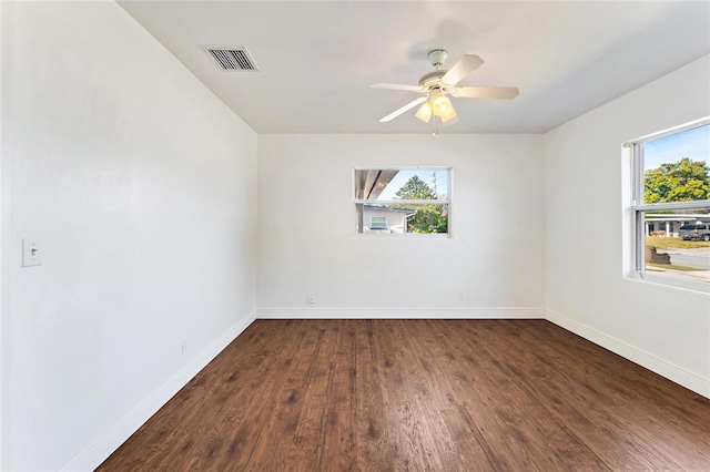 unfurnished room with plenty of natural light, dark hardwood / wood-style floors, and ceiling fan