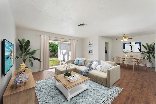 living room with ceiling fan, wood-type flooring, and a textured ceiling