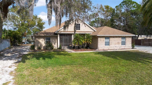 view of front of home with a sunroom and a front lawn