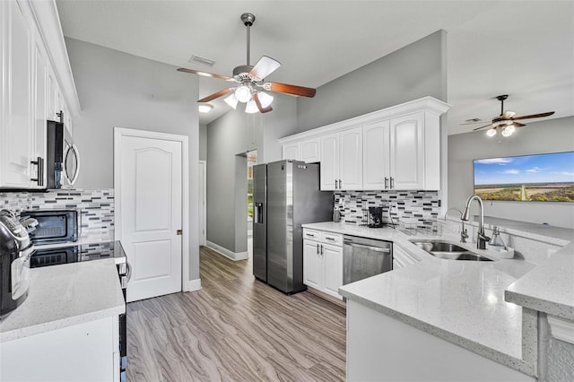 kitchen featuring white cabinetry, sink, kitchen peninsula, and appliances with stainless steel finishes