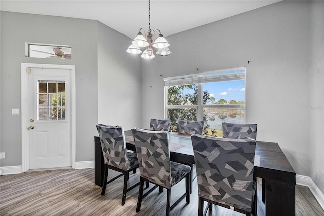 dining area with a wealth of natural light, hardwood / wood-style floors, and a notable chandelier