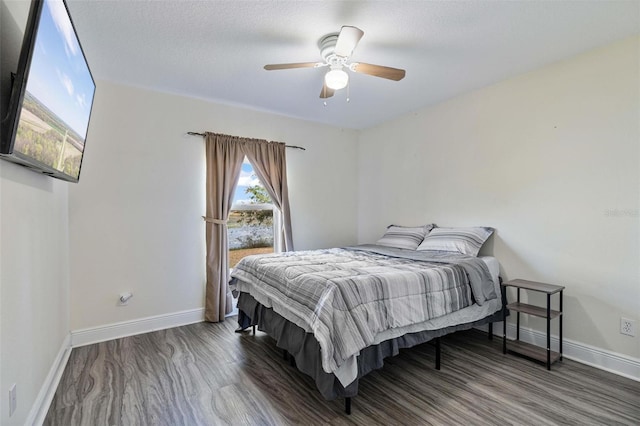 bedroom featuring dark wood-type flooring, a textured ceiling, and ceiling fan