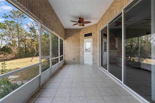 unfurnished sunroom featuring ceiling fan