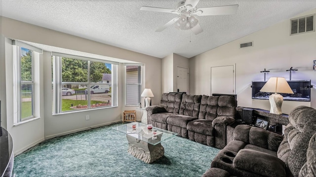 living room with ceiling fan, lofted ceiling, carpet floors, and a textured ceiling