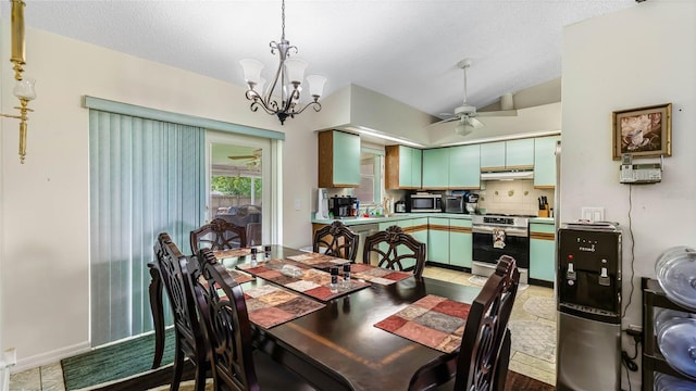 dining room featuring vaulted ceiling, ceiling fan with notable chandelier, and a textured ceiling