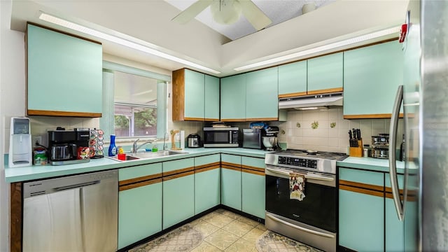 kitchen featuring sink, ceiling fan, appliances with stainless steel finishes, light tile patterned flooring, and decorative backsplash