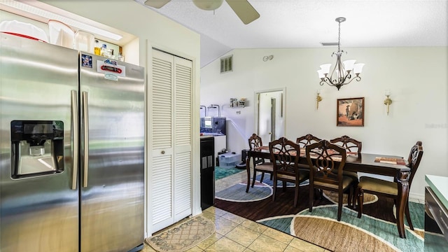 tiled dining space with lofted ceiling and ceiling fan with notable chandelier