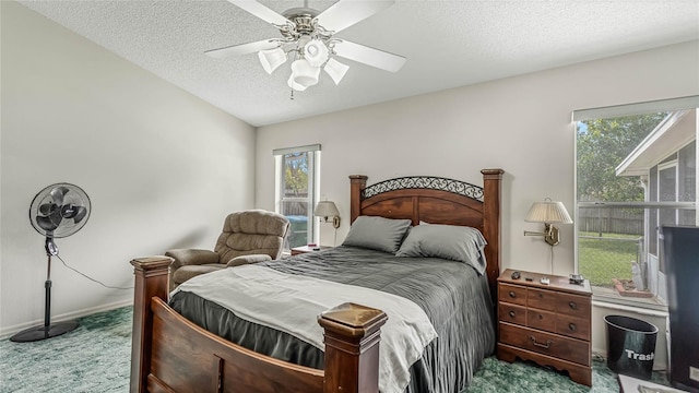 bedroom with multiple windows, ceiling fan, carpet, and a textured ceiling