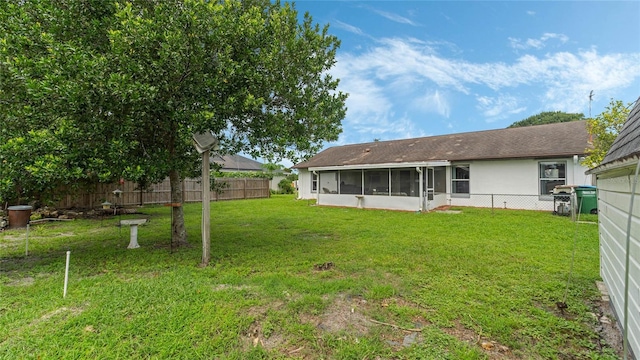 back of property featuring a lawn and a sunroom