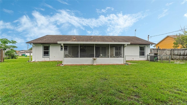 rear view of house featuring a yard and a sunroom