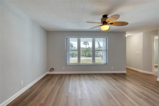 unfurnished room featuring ceiling fan, light hardwood / wood-style floors, and a textured ceiling