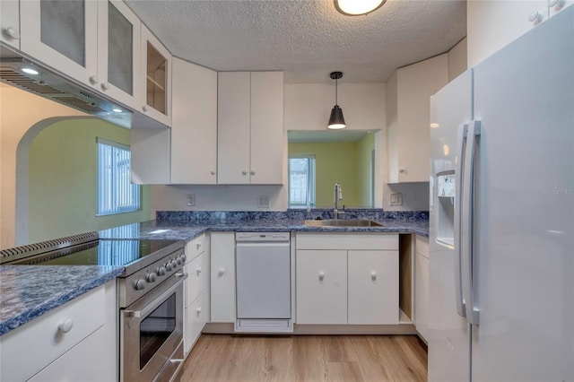 kitchen with sink, pendant lighting, white appliances, light hardwood / wood-style floors, and white cabinets