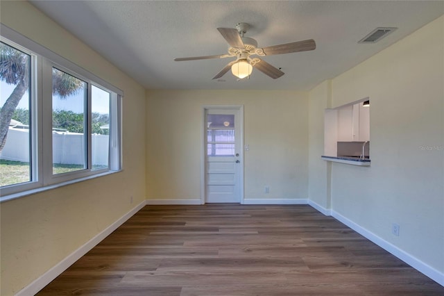 spare room featuring wood-type flooring, ceiling fan, and a textured ceiling