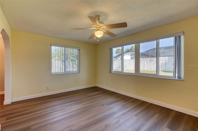 unfurnished room featuring ceiling fan, a healthy amount of sunlight, wood-type flooring, and a textured ceiling