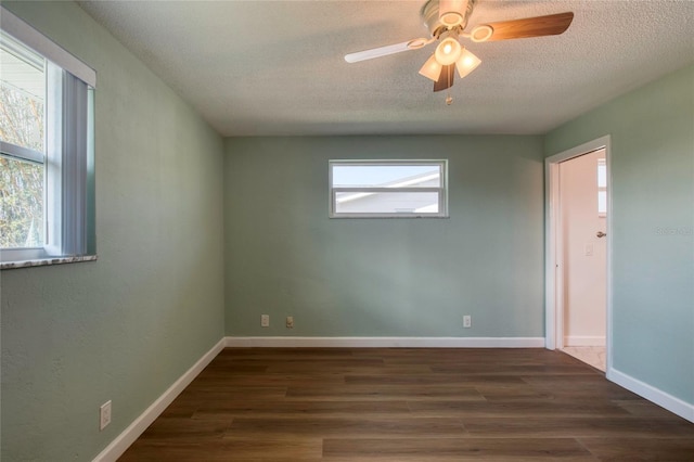 empty room featuring dark wood-type flooring, ceiling fan, and a textured ceiling