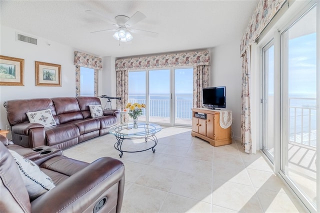 living room featuring light tile patterned flooring, a textured ceiling, and ceiling fan