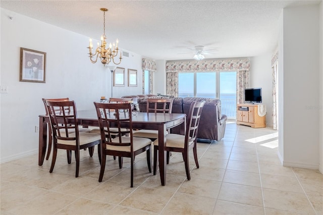 tiled dining space featuring ceiling fan with notable chandelier and a textured ceiling