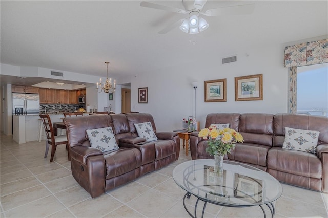 living room featuring ceiling fan with notable chandelier and light tile patterned flooring