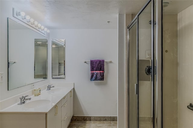 bathroom featuring tile patterned flooring, vanity, and a shower with shower door