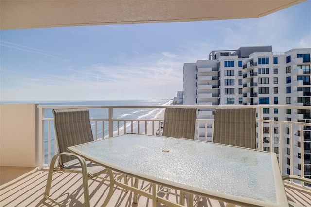 balcony with a water view and a view of the beach