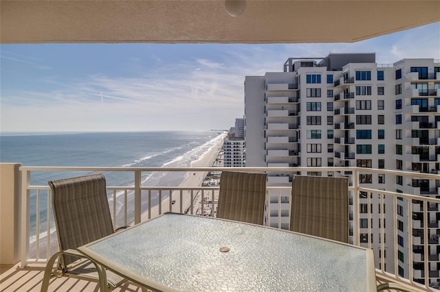 balcony featuring a view of the beach and a water view