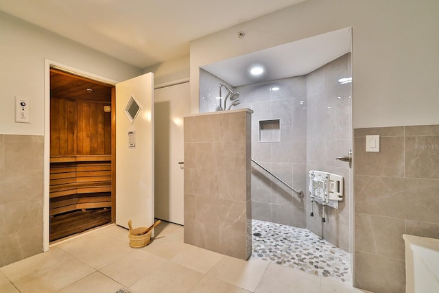 bathroom featuring a tile shower, tile patterned floors, and tile walls