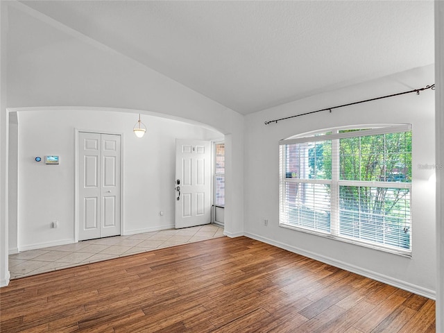 entryway with lofted ceiling and light hardwood / wood-style flooring