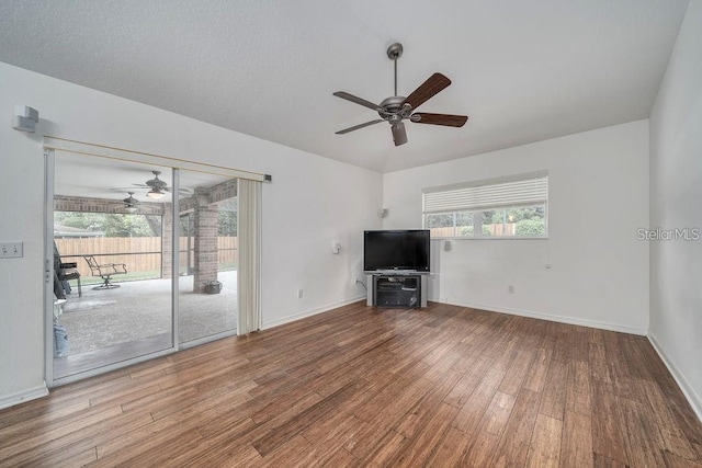 unfurnished living room with wood-type flooring, ceiling fan, and vaulted ceiling