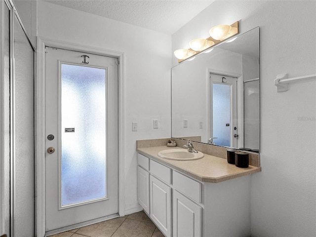 bathroom featuring tile patterned floors, vanity, a textured ceiling, and plenty of natural light